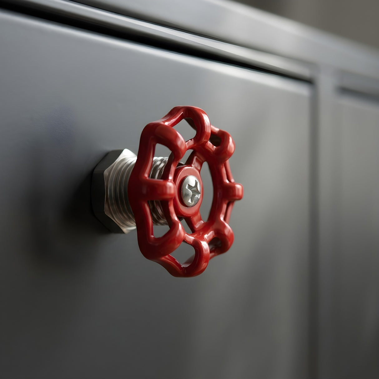 Bouton de meuble volant rouge style industriel sur meuble métal gris