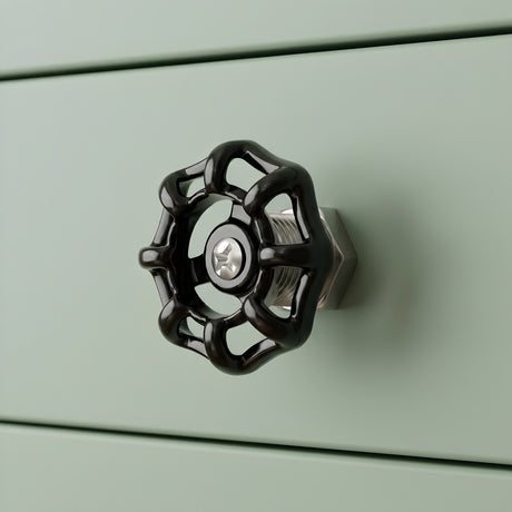 Bouton de meuble volant noir sur tiroir vert sauge